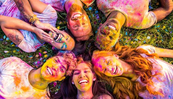 Group of friends with colorful faces celebrating Holi