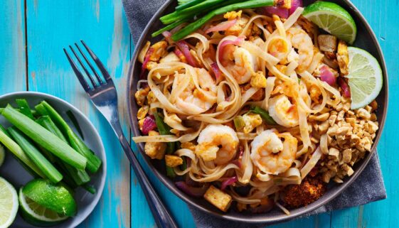 A plateful of shrimp pad thai on a table