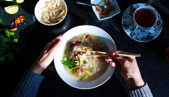 A person enjoying a bowl of Phở